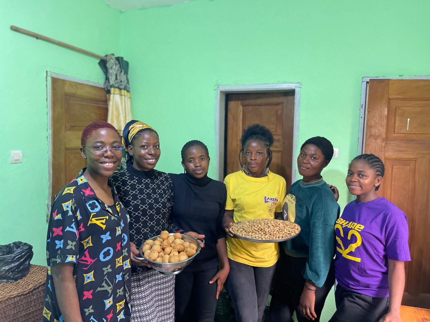 Pastry trainees proudly showing the doughnuts and peanuts they made