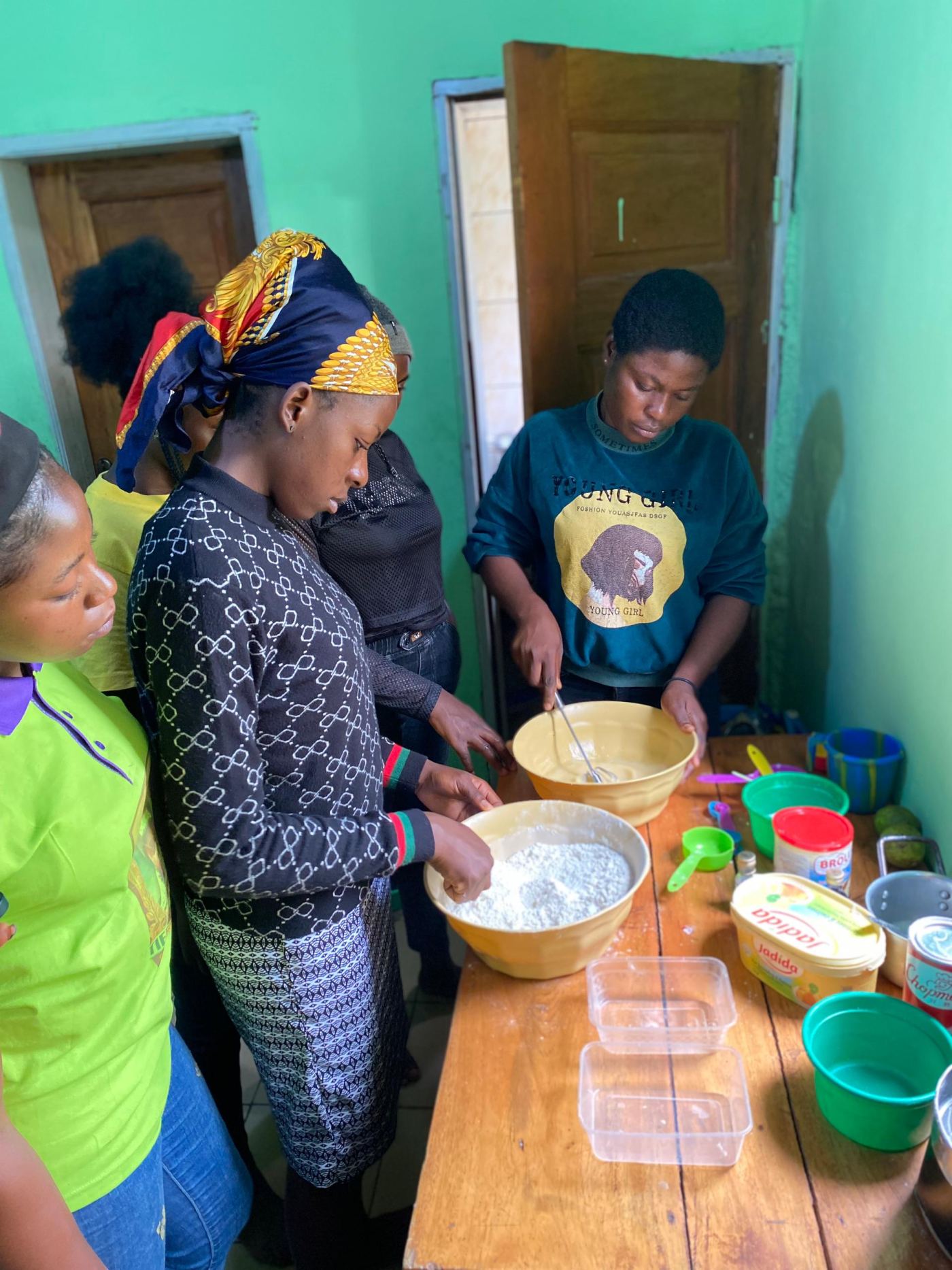 Trainees gathered around bowls of dough during a pastry session