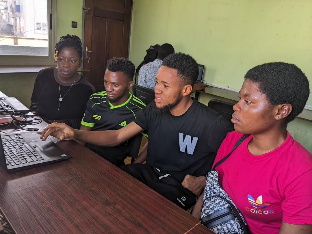 Students learning at a computer with a supervisor at Skye8